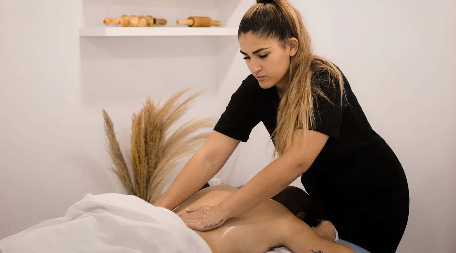 La Marta fa un massatge d'esquena a una clienta a la cabina d'Adara Essence