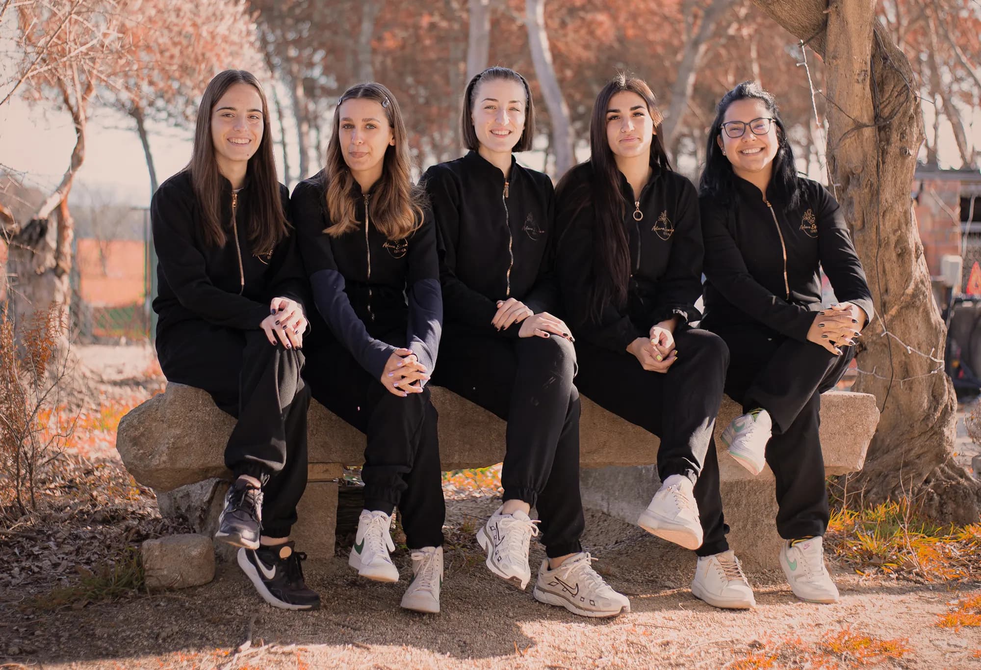El equipo de Adara Essence sentado en un banco de piedra junto a la masía