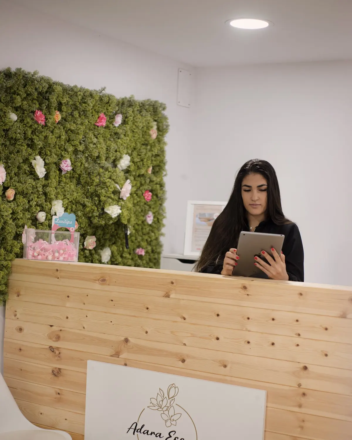 Recepció d'Adara Essence, amb una paret de plantes i flors